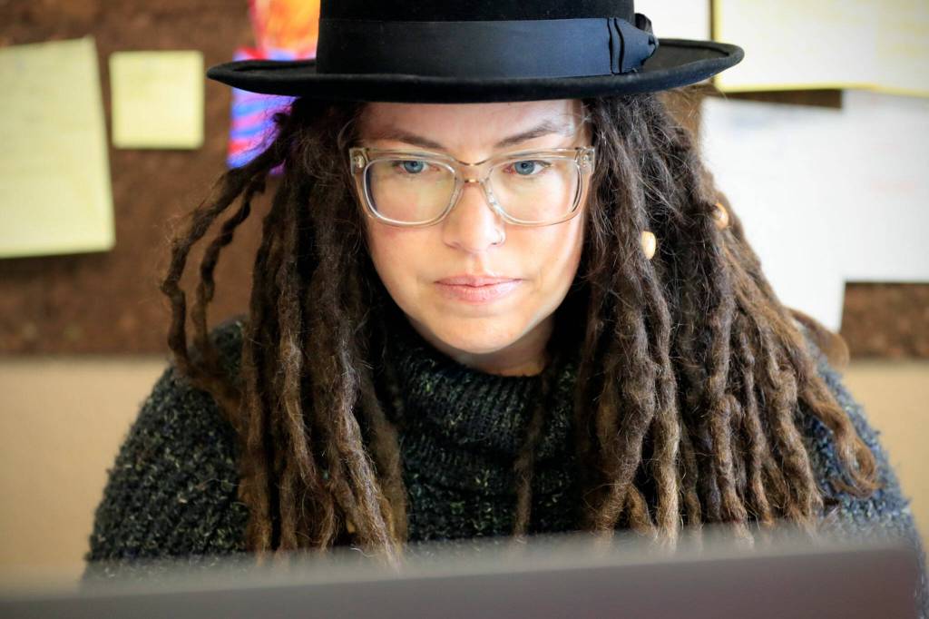 Jill Cash works through the paper work at the FauxyFurr manufacturing shop in Arlington. (Kevin Clark / The Herald )