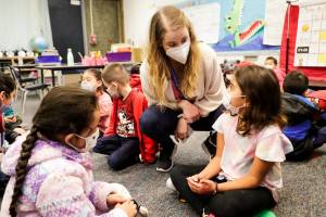 Erika Rabura, teacher, talks to Isabella Bauta, right, with Pilar Garcia Monday morning at College Place Elementary School in Lynnwood, Washington on March 7, 2022. (Kevin Clark / The Herald)