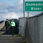 Two cyclists head eastbound along the Highway 2 trestle path Saturday, March 5, 2022, in Everett, Washington. (Ryan Berry / The Herald)