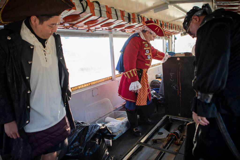 George Safadago pulls up the floor panels in the 1945 DUKW in Mukilteo. (Olivia Vanni / The Herald)