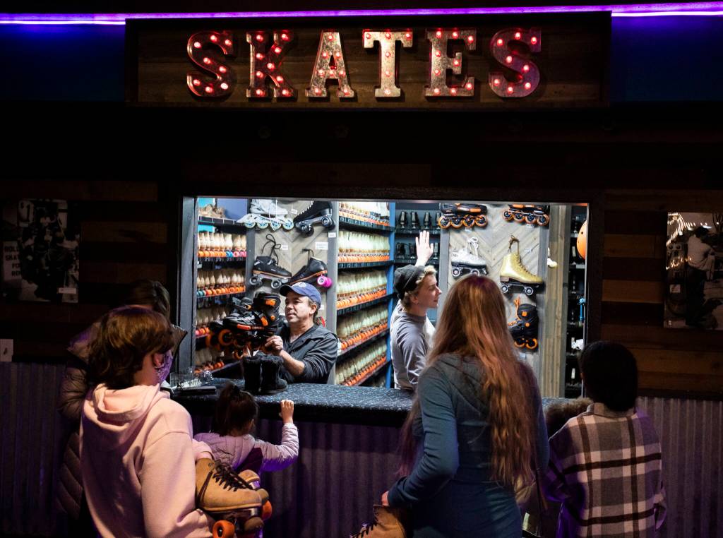 People line up to trade in their shoes for skates on family night at the Everett Skate Deck. (Olivia Vanni / The Herald)
