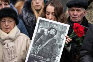 A relative holds photo of a soldier killed defending Donetsk airport in 2014-15 in a war conflict with Russia-backed separatists during a commemorating ceremony in Kyiv, Ukraine, Monday, Jan. 20, 2019. Ukraine has asked the Organization for Security and Cooperation in Europe to expand its monitoring mission in the country, Foreign Minister Vadym Prystaiko said Monday after a meeting with the organization's chairman.
 (Ukrainian Presidential Press Office via AP)