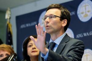 FILE - Washington Attorney General Bob Ferguson talks to reporters, Monday, Aug. 26, 2019, during a news conference in Seattle. A trade group that represents some of the biggest U.S. food companies has agreed to pay $9 million for violations of Washington campaign finance laws, after the state Supreme Court upheld a penalty twice that much. Ferguson, who sued the group in 2013, announced it was dropping its appeal and would instead settle the case for $9 million, including $3 million in donations to two charities that fight hunger. (AP Photo/Ted S. Warren,File)