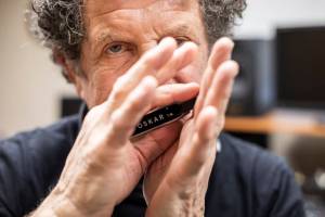 Lee Oskar plays on one of his custom harmonicas in his recording studio in his home on Wednesday, March 2, 2022 in Everett, Washington. (Olivia Vanni / The Herald)
