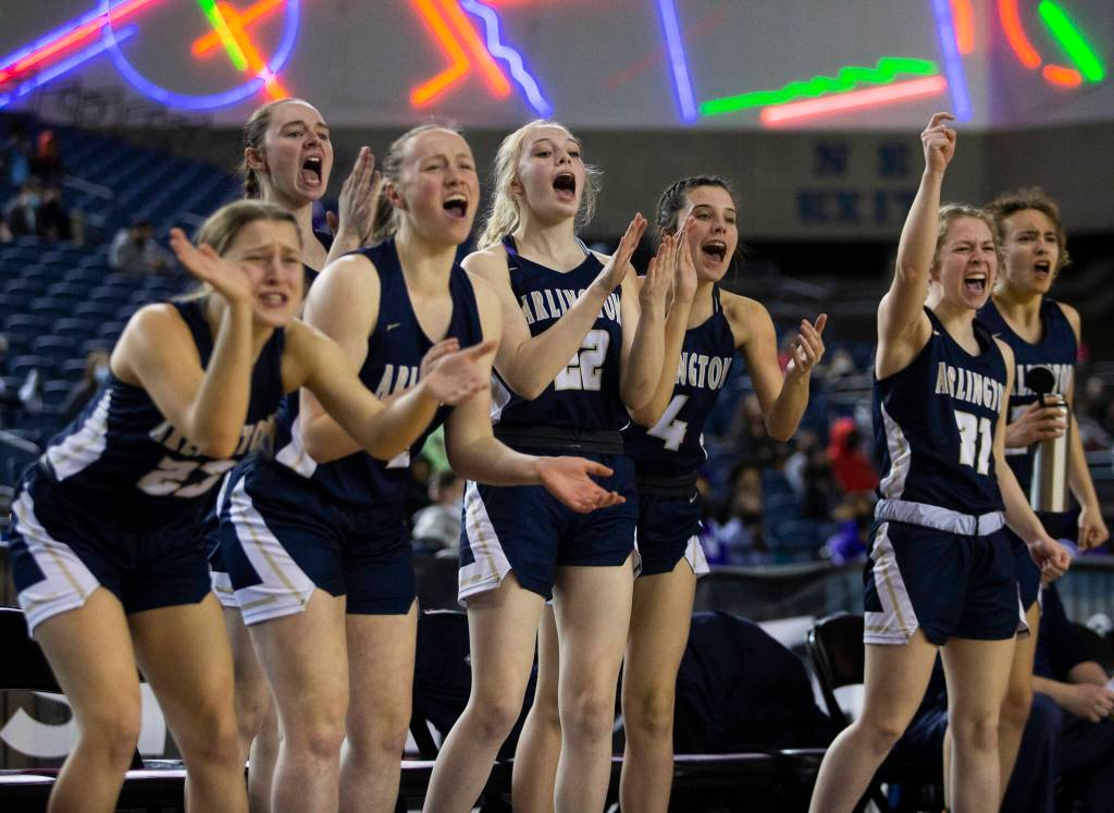 The Arlington bench reacts to a three-point shot during the 3A state semifinal against Garfield at the Tacoma Dome on Friday, March 4, 2022. (Olivia Vanni / The Herald)
