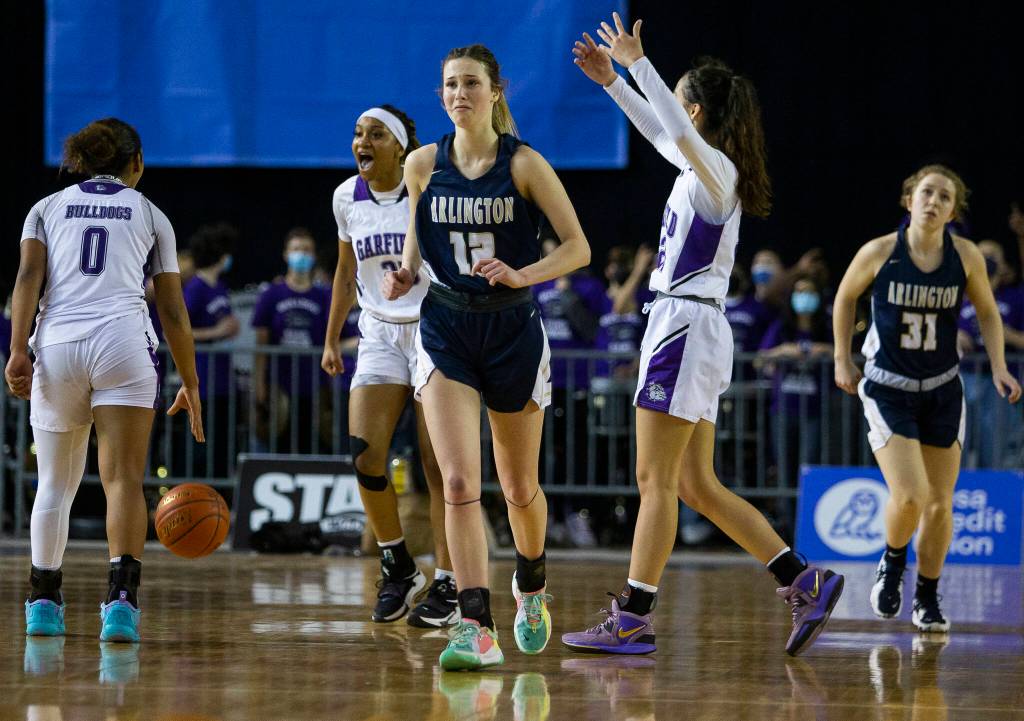 Arlington players react to losing to Garfield in the 3A state semifinal at the Tacoma Dome on Friday, March 4, 2022. (Olivia Vanni / The Herald)