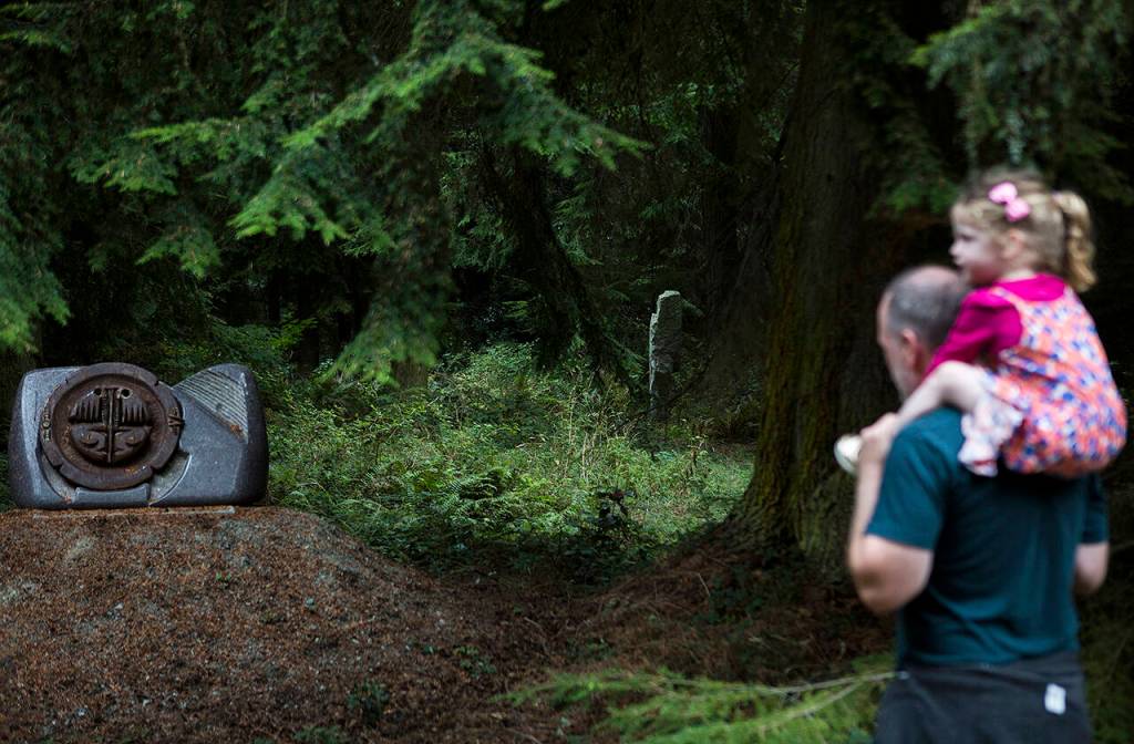 People in a tour group look and listen as two sculptures are explained at the Cloudstone Sculpture outdoor gallery in Freeland on Whidbey Island in 2018. (Olivia Vanni / Herald file)