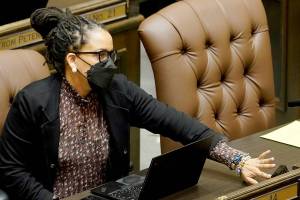 Rep. April Berg, D-Mill Creek, pushes a button to cast a vote on the House floor, Thursday, March 10, 2022, at the Capitol in Olympia, Wash. Washington lawmakers were wrapping up their work Thursday with final votes on a supplemental state budget and a transportation revenue package before planning to adjourn the legislative session. (AP Photo/Ted S. Warren)
