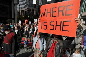 Dennis Willard, of Bellevue, Wash., carries a sign that reads "Where Is She" as he marches in support of missing and murdered indigenous women during a rally to mark Indigenous Peoples' Day in downtown Seattle, Monday, Oct. 14, 2019. The observance of the day was made official by the Seattle City Council in 2014, and it takes place annually on the federal holiday of Columbus Day. (AP Photo/Ted S. Warren)