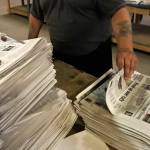 FILE - An employee sorts newspapers for delivery at a distribution center in Liberty Township near Youngstown, Ohio, on Aug. 6, 2019. Pew Research Center data released this week showed that 2020 was the first year that the newspaper industry earned more money from circulation than advertising, (AP Photo/Tony Dejak, File)
