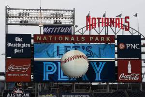 FILE - The scoreboard plays the seventh inning stretch themes of the Toronto Blue Jays during the middle of the seventh inning of a baseball game between the Blue Jays and the Washington Nationals, on July 30, 2020, in Washington. Players voted Thursday, March 10, 2022, to accept MLB's offer on new labor deal, paving way to end 99-day lockout and salvage 162-game season. (AP Photo/Nick Wass, File)