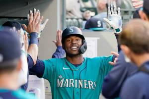 Seattle Mariners' Kyle Lewis is congratulated after his two-run home run against the Texas Rangers in the third inning of a baseball game Friday, May 28, 2021, in Seattle. (AP Photo/Elaine Thompson)