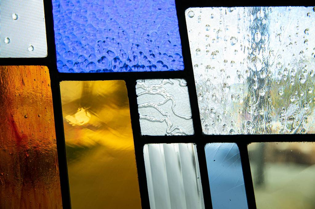 Stained glass tiles show different textures in one of Jack Archibalds windows at Stanwood High School. (Ryan Berry / The Herald)
