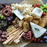 Savory salami cheesecake, layered pesto torte, award-winning olive tapenade, fresh fruit, crostini and more cover Charcuterie by Stephanies bountiful boards. (Taylor Goebel / The Herald)