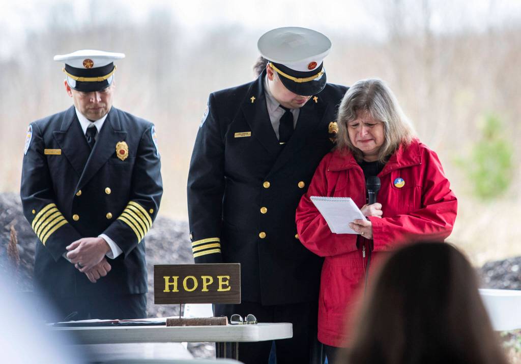 Gail Thompson is comforted by Chaplin Joel Johnson while she reads a speech she wrote earlier in the morning at the Oso Memorial on Tuesday in Oso. (Olivia Vanni / The Herald)