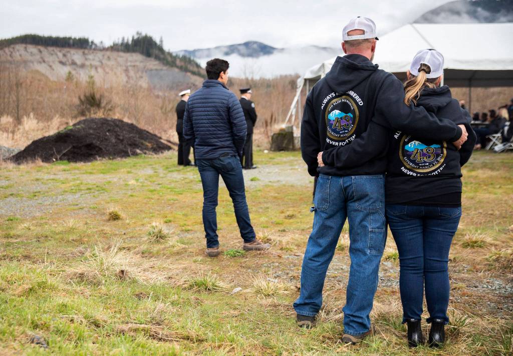 People take a moment of silence at 10:37 a.m. at the Oso Memorial on Tuesday in Oso. (Olivia Vanni / The Herald)