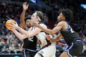 Gonzaga forward Drew Timme, center, drives between Georgia State guard Kane Williams (12) and guard Collin Moore, right, during the second half of a first round NCAA college basketball tournament game, Thursday, March 17, 2022, in Portland, Ore. (AP Photo/Craig Mitchelldyer)