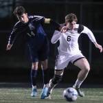 Arlingtons Emmanuel Escalante, left, and Monroes Owen Skurdal chase down the ball Friday evening at Arlington High School in Arlington, Washington on March 18, 2022. (Kevin Clark / The Herald)