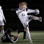 Monroes Cody Duncan kicks the ball free with Arlingtons Lucas Frazier Friday evening at Arlington High School in Arlington, Washington on March 18, 2022. (Kevin Clark / The Herald)