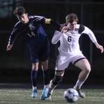 Arlingtons Emmanuel Escalante, left, and Monroes Alexis Pacheco-Alonso chase down the ball Friday evening at Arlington High School in Arlington, Washington on March 18, 2022. (Kevin Clark / The Herald)