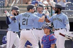 Seattle Mariners' Steven Souza Jr. (21) celebrates with teammates after hitting a grand slam during the first inning of a spring training baseball game against the Los Angeles Dodgers Saturday, March 19, 2022, in Peoria, Ariz. (AP Photo/Charlie Riedel)