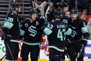 Seattle Kraken center Yanni Gourde, second from left, is congratulated by defenseman Carson Soucy (28) and center Colin Blackwell (43) after scoring his second goal against the Detroit Red Wings during the third period of an NHL Hockey game Saturday, March 19, 2022, in Seattle. The Kraken won 4-2. (AP Photo/John Froschauer)