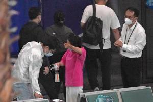 A woman reacts as she prepares to leave an area for relatives of the passengers aboard China Eastern's flight MU5735 at the Guangzhou Baiyun International Airport, Tuesday, March 22, 2022, in Guangzhou. No survivors have been found as rescuers on Tuesday searched the scattered wreckage of a China Eastern plane carrying 132 people that crashed a day earlier on a wooded mountainside in China's worst air disaster in more than a decade. (AP Photo/Ng Han Guan)