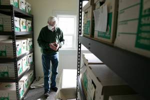 Mukilteo Historical Society volunteer Peter Anderson stands in an archive of historic objects that have been filed away at the Mukilteo Lighthouse on Thursday, March 24, 2022, in Mukilteo, Washington. (Ryan Berry / The Herald)