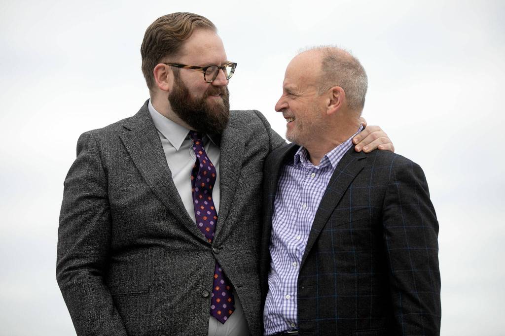 Sen. Marko Liias and Rep. Jake Fey celebrate as Gov. Jay Inslee signs a number of bills into law during the bill signing. (Ryan Berry / The Herald)