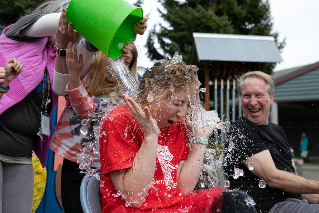 Students help douse second grade teacher Katelyn Pancake-Boal with water. (Ryan Berry / The Herald)