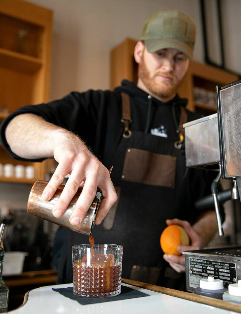 Owner Jacob Ort pours a non-alcoholic old fashioned, made with espresso, at Nadines Coffee House on Friday in Everett. (Ryan Berry / The Herald)