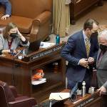 Sen. Andy Billig (D-Spokane), second from right, confers with Sen. Sam Hunt, D-Olympia, right, in front of Sen. June Robinson's, D-Everett, desk on the Senate floor at the Capitol in Olympia, Wash., on Tuesday, Feb. 15, 2022, during debate over a measure that authorizes legislative leaders to terminate any state of emergency called by the governor after 90 days if the Legislature is not in session. The measure passed the Democratic-led Senate chamber and now heads to the House, also held by Democrats, for consideration. (AP Photo/Ted S. Warren)