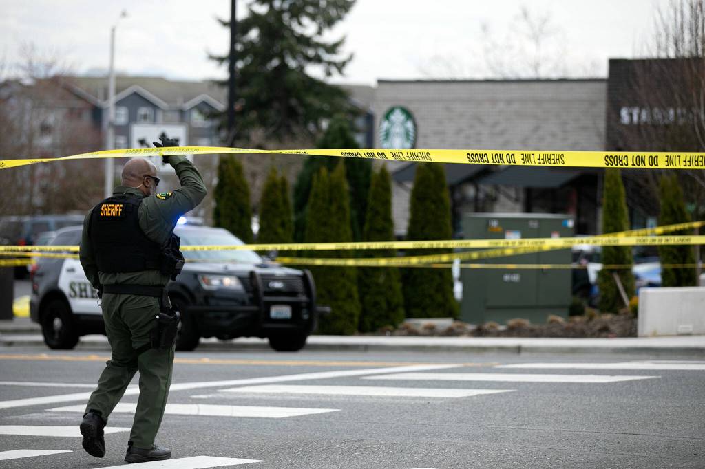 Law enforcement work near the Starbucks at 1010 N Broadway where an officer was killed Friday afternoon in Everett, Washington. (Ryan Berry / The Herald)