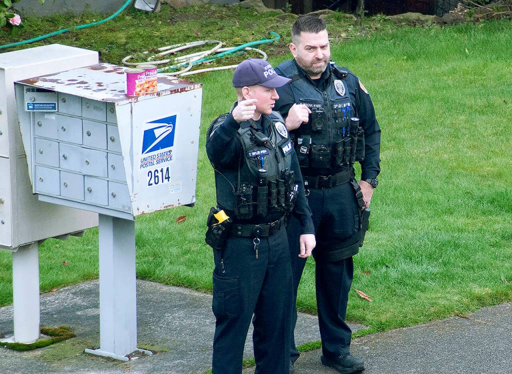 Everett Police Officer Dan Rocha (right) and Everett Police Officer T. Taylor, seen Friday morning during a stop in the 2600 block of Rucker Avenue. (Sue Misao / The Herald)