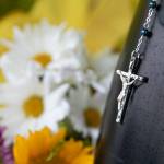 A small crucifix hangs from the bumper of a police vehicle at officer Dan Rochas memorial Saturday in Everett. (Ryan Berry / The Herald)
