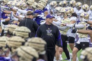 University of Washington coach Kalen Deboer walks among players and staff as they perform early morning warmups during NCAA football practice, Wednesday, March 30, 2022. (Steve Ringman/The Seattle Times via AP)