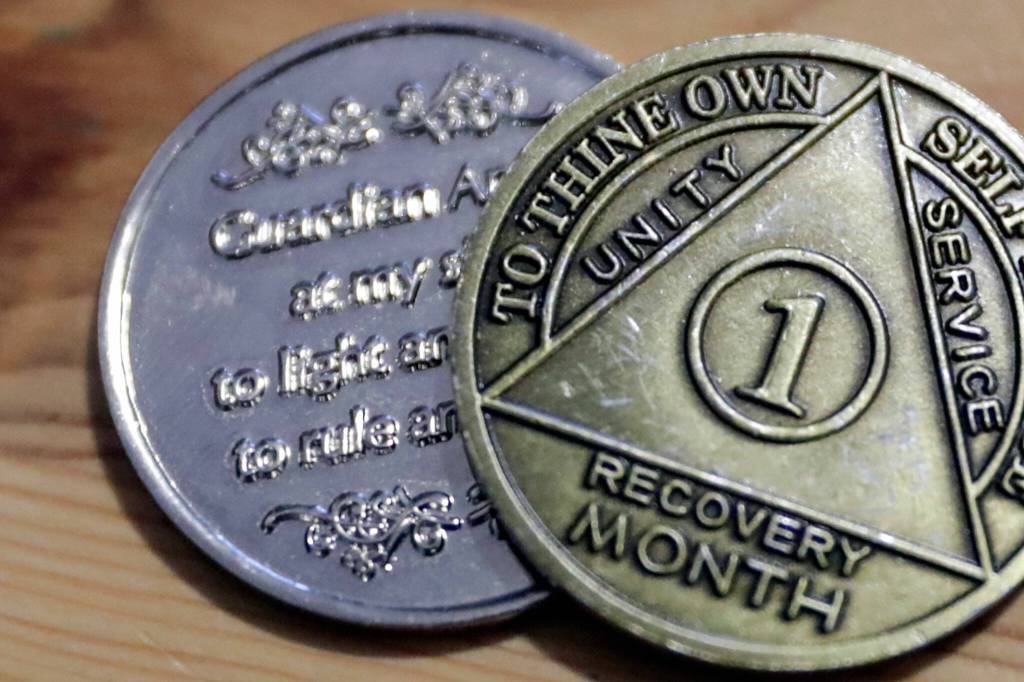 Randy Tharps recovery coins, which he received after battling fentanyl addiction. (Kevin Clark / The Herald)