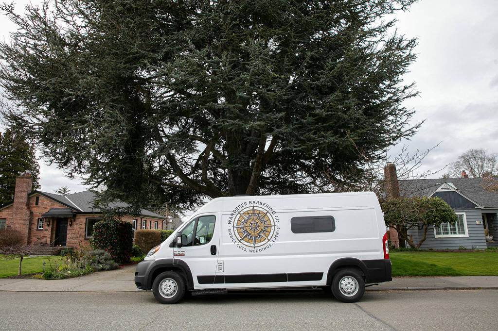 The Wanderer Barbering Co. van is parked in front of a clients home. (Ryan Berry / The Herald)