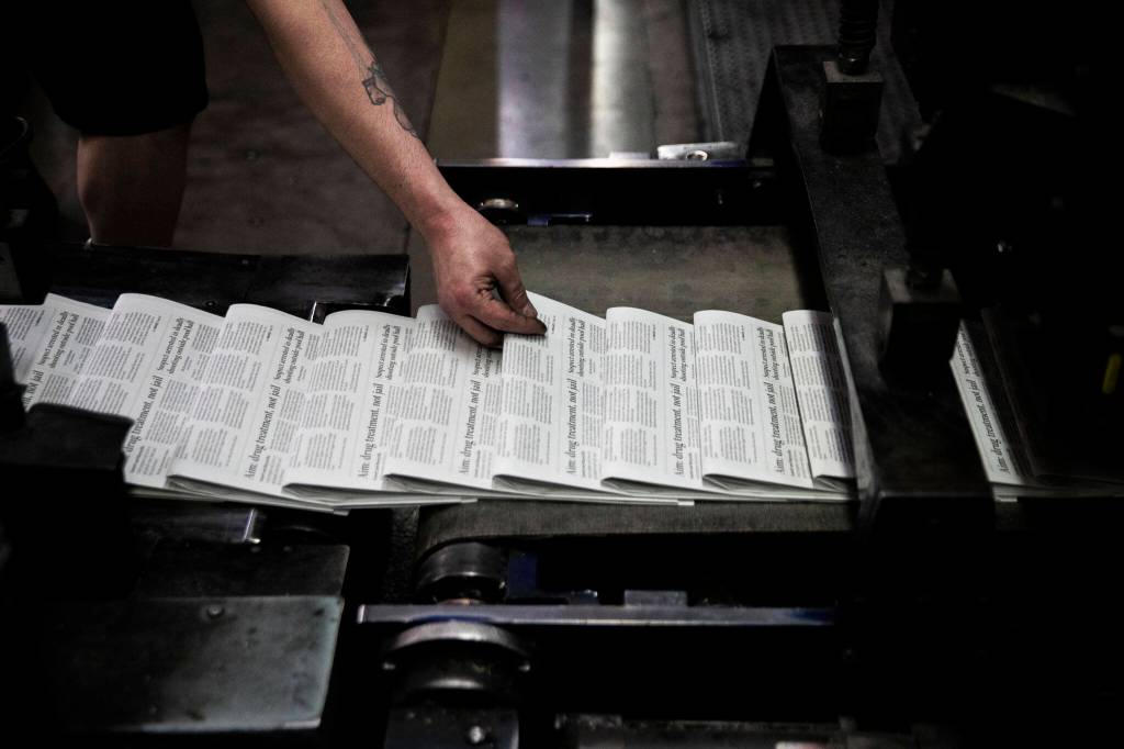 Mike Tullar grabs a copy of The Herald to check for quality at the press at Paine Field in Everett. (Olivia Vanni / The Herald)