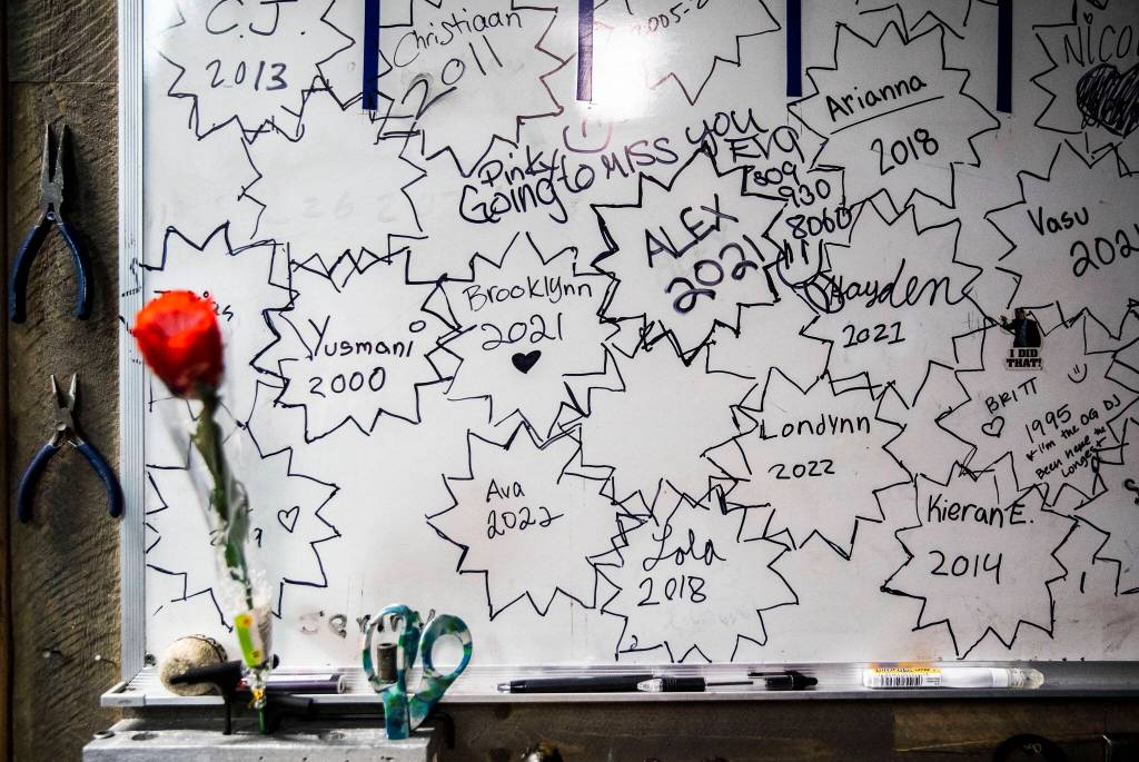 Names of former and current employees and the years they started working at the Everett Skate Deck cover a whiteboard in the skate room. (Olivia Vanni / The Herald)