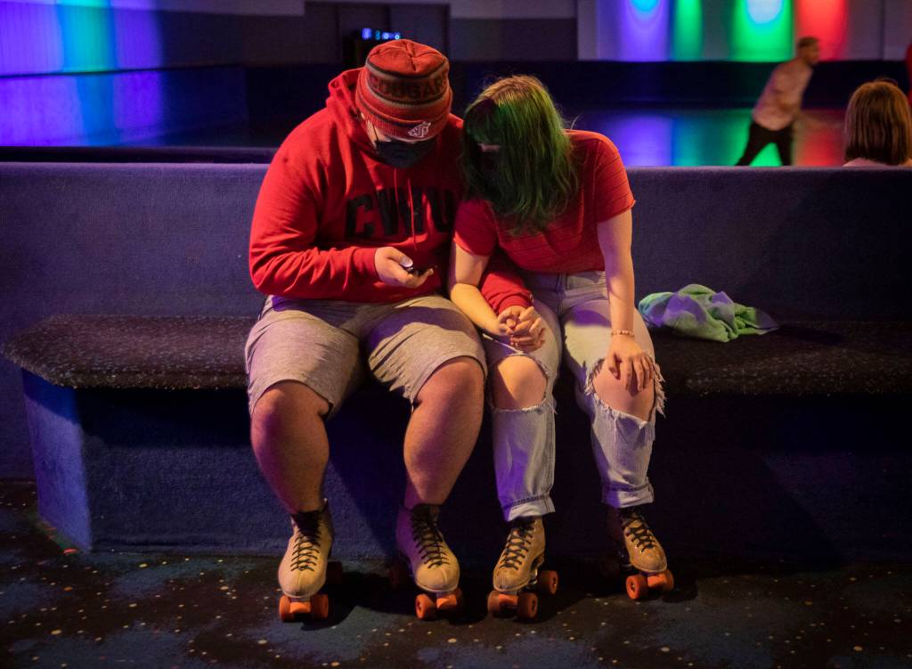 Layney Dodd and Michael Noonan hold hands before heading out onto the floor on Sunday at the Everett Skate Deck. (Olivia Vanni / The Herald)
