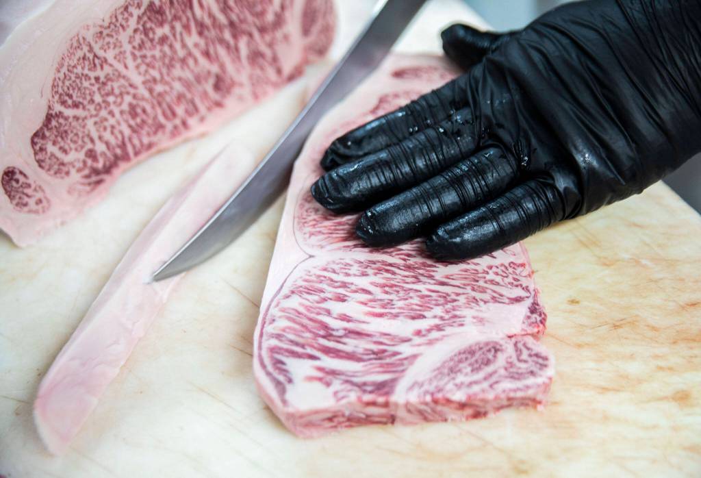 Sean Sanderson slices a Japanese Wagyu loin at EC Wilson Meat Co. in Lynnwood. (Olivia Vanni / The Herald)
