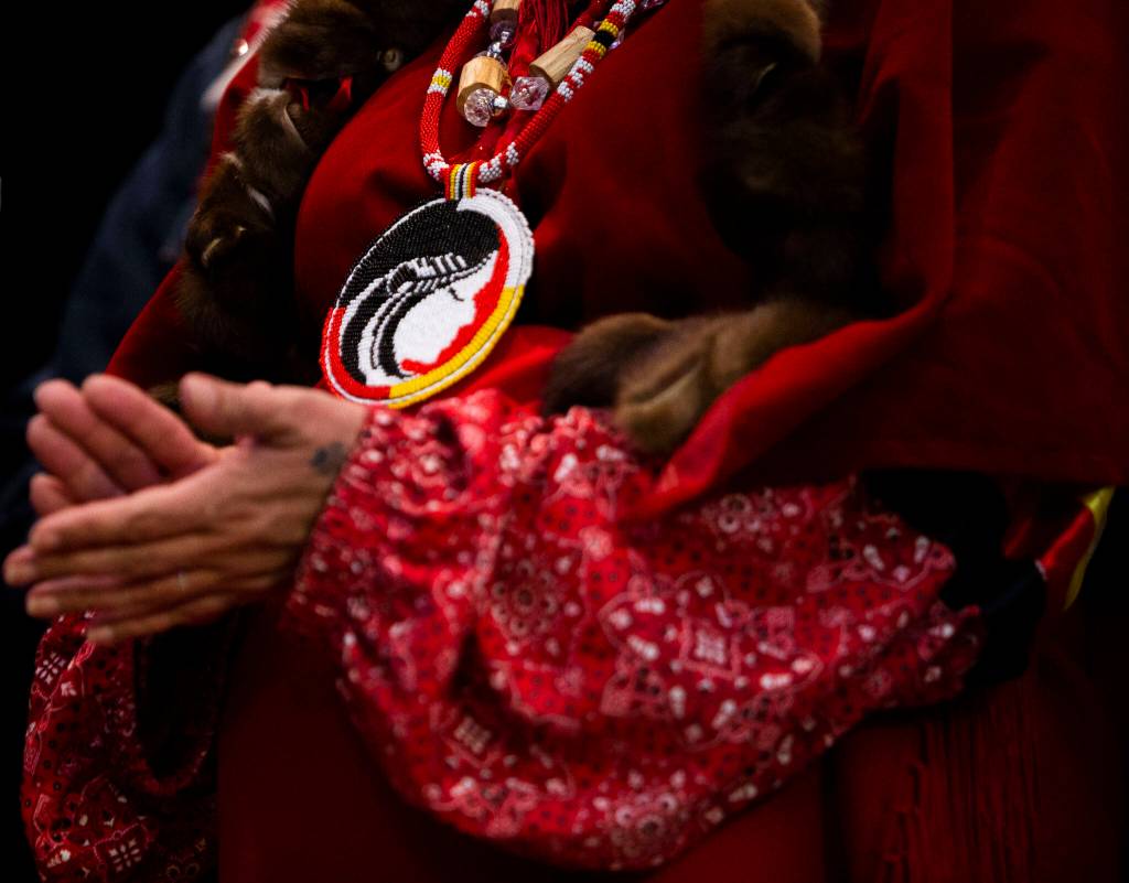 Earth-feather Sovereign claps while Gov. Jay Inslee signs HB 1725 into law. (Olivia Vanni / The Herald)