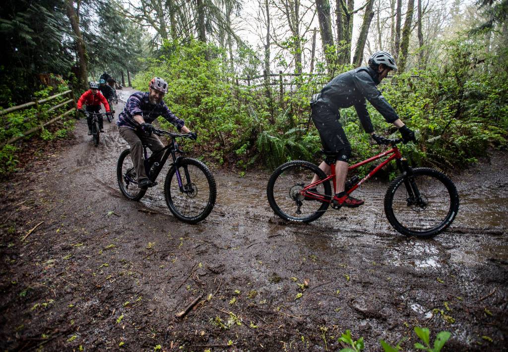 Bikers ride down a hill into Lord Hill Park near Snohomish during their gathering on April 10. (Olivia Vanni / The Herald)
