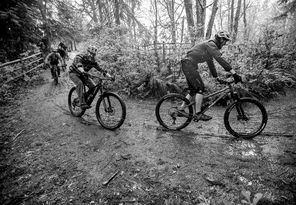 Bikers ride down a hill into Lord Hill Park during their protest on Sunday, April 10, 2022 in Snohomish, Washington. (Olivia Vanni / The Herald)