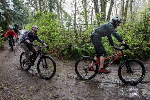 Bikers ride down a hill into Lord Hill Park during their protest on Sunday, April 10, 2022 in Snohomish, Washington. (Olivia Vanni / The Herald)