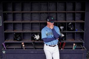 Seattle Mariners manager Scott Servais waits in the dugout before a spring training baseball game against the Kansas City Royals Tuesday, March 29, 2022, in Peoria, Ariz. (AP Photo/Charlie Riedel)
