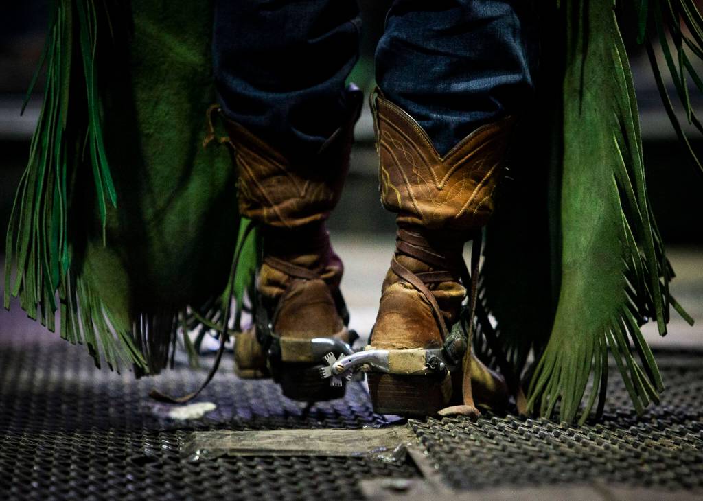 A bull rider walks into the chutes during the PBR Everett Invitational at Angel of the Winds Arena on Wednesday, April 6, 2022 in Everett, Washington. (Olivia Vanni / The Herald)