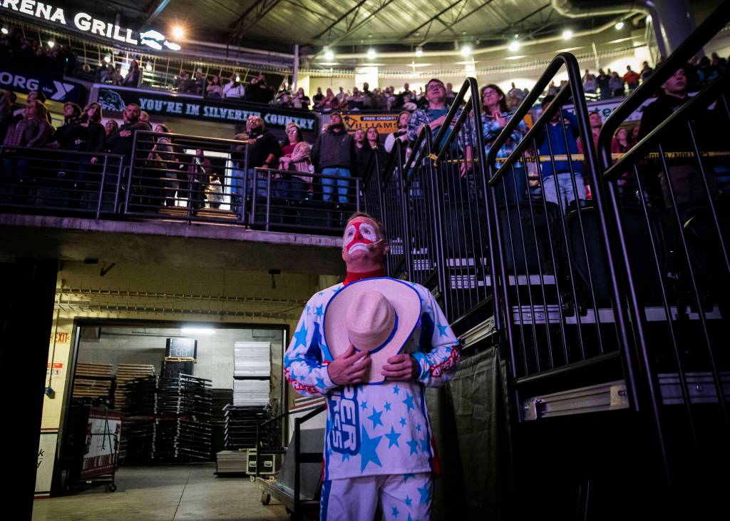 PBR rodeo entertainer Flint Rasmussen pauses for the National Anthem before entering the arena during the PBR Everett Invitational at Angel of the Winds Arena on Wednesday, April 6, 2022 in Everett, Washington. (Olivia Vanni / The Herald)
