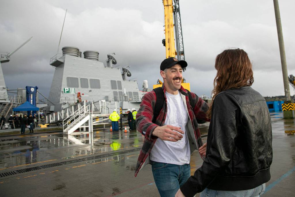 Keenan Parsons runs to greet his wife, Roxanne, after disembarking from the USS McCampbell Friday at Naval Station Everett. (Ryan Berry / The Herald)